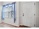 Bright entryway featuring hardwood floors, a white door, and a window with sheer blue curtains at 510 Riverview Ln, Canton, GA 30114
