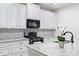 Bright kitchen with white cabinets, granite countertops, stainless appliances, and a tiled backsplash at 510 Riverview Ln, Canton, GA 30114