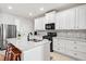 Modern kitchen with white cabinets, granite countertops, stainless steel appliances, and a central island with seating at 510 Riverview Ln, Canton, GA 30114