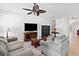 Open-concept living room with comfortable seating, wood floors, ceiling fan, and entertainment center at 510 Riverview Ln, Canton, GA 30114