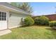 Cozy backyard featuring a small patch of green grass, mature bushes, and access door at 218 Ridley Ln, Decatur, GA 30030