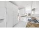 All-white kitchen features tiled flooring, granite countertops, and modern appliances at 218 Ridley Ln, Decatur, GA 30030