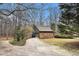 Detached stone garage with grey siding is surrounded by mature trees at 3341 Camelot Way, Loganville, GA 30052