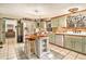 Charming kitchen features light green cabinets, center island and white appliances at 3341 Camelot Way, Loganville, GA 30052