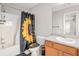 Bright bathroom featuring a shower-tub combo, vanity, and stylish sunflower-themed decor at 3956 Church View Ln, Suwanee, GA 30024