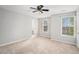 Neutral bedroom features two windows and plush carpet with view to the attached bath at 3956 Church View Ln, Suwanee, GA 30024