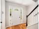 Bright foyer with hardwood floors, white door with sidelights, and staircase at 3956 Church View Ln, Suwanee, GA 30024