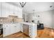 Bright kitchen with white cabinets, stainless steel appliances, and an adjacent dining area with modern lighting at 3956 Church View Ln, Suwanee, GA 30024