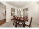 Dining room with a dark wood table, neutral walls, and access to the kitchen at 11973 Lovejoy Crossing Way, Hampton, GA 30228