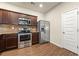 Modern kitchen featuring stainless steel appliances, granite countertops, and dark wood cabinets at 11973 Lovejoy Crossing Way, Hampton, GA 30228