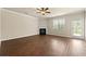 Spacious living room featuring hardwood floors, a ceiling fan, a fireplace, and access to a back yard at 11973 Lovejoy Crossing Way, Hampton, GA 30228