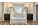 Bright main bathroom boasts a soaking tub with separate vanities and mirrors for a luxurious feel at 11973 Lovejoy Crossing Way, Hampton, GA 30228