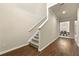 Hallway staircase leads to a dining room, illuminated by modern lighting, in a neutral color palette at 11973 Lovejoy Crossing Way, Hampton, GA 30228