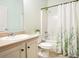 Bright bathroom featuring a tub/shower combo with green-themed shower curtain and a single-sink vanity at 3804 Hawk Tail Dr, Loganville, GA 30052
