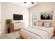 Modern bedroom with wooden bed frame, a wall-mounted TV, and a minimalist, light-filled interior at 3804 Hawk Tail Dr, Loganville, GA 30052