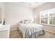 Sunlit bedroom featuring a double window, neutral walls, and a dresser with decorative accents at 3804 Hawk Tail Dr, Loganville, GA 30052