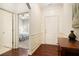 Inviting entryway with hardwood floors, decorative wainscoting, and a view into the bedroom at 3804 Hawk Tail Dr, Loganville, GA 30052