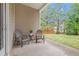 Covered back patio with two chairs and a table, overlooking a green backyard with a wooden fence at 3804 Hawk Tail Dr, Loganville, GA 30052