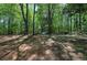 Expansive backyard is surrounded by lush trees and a canopy of shade, offering a serene and private outdoor space at 4361 Stanley Dr, Powder Springs, GA 30127