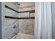 Close-up of a shower featuring marble-patterned tiles, a built-in niche, and a shower head with a clean white curtain at 4361 Stanley Dr, Powder Springs, GA 30127