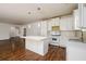 Well-lit kitchen with a center island, white cabinets, and stainless steel appliances at 742 Hope Hollow Ln, Loganville, GA 30052