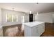 The open-concept kitchen features a center island, white cabinets, and wood-look flooring at 742 Hope Hollow Ln, Loganville, GA 30052