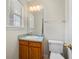 A bathroom featuring a window, a mirror, a sink and toilet, with tan walls at 5908 Trent Walk Dr, Lithonia, GA 30038