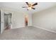 Bedroom with carpet, fan, and doors to a hallway and ensuite bath at 5908 Trent Walk Dr, Lithonia, GA 30038