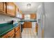 A kitchen featuring wood cabinets, green countertops, tile flooring, and white appliances at 5908 Trent Walk Dr, Lithonia, GA 30038