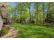 Private backyard offers a serene setting with lush green grass, a stone pathway, and a firepit area at 1155 Christian Se Cir, Conyers, GA 30013