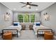 Bright bedroom with two twin beds, neutral walls, and a ceiling fan at 1155 Christian Se Cir, Conyers, GA 30013