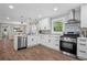 Bright kitchen featuring white cabinetry, stainless steel appliances, and stylish backsplash at 1155 Christian Se Cir, Conyers, GA 30013