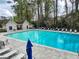 Large community pool surrounded by mature trees with ample lounge chairs and umbrellas for relaxation at 2168 Rock Creek Park, Decatur, GA 30033