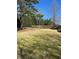 Large, grassy backyard featuring a classic wooden fence and mature trees at 4264 Parks Ridge Dr, Snellville, GA 30039