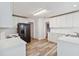 Spacious kitchen featuring stainless steel refrigerator, white cabinets, and modern wood-look flooring, perfect for cooking at 4264 Parks Ridge Dr, Snellville, GA 30039