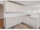 Bright kitchen featuring white cabinets, light countertops, and stainless steel sink with modern wood-look flooring at 4264 Parks Ridge Dr, Snellville, GA 30039