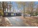 Charming single-story home featuring a blue front door and a spacious driveway surrounded by mature trees and fall foliage at 799 Kennesaw Dr, Forest Park, GA 30297