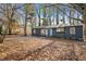 Charming exterior featuring a grey painted home, a blue door, and a leaf-covered front yard and drive at 799 Kennesaw Dr, Forest Park, GA 30297
