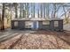 Charming exterior featuring a grey painted home, a blue door, and a leaf-covered front yard and drive at 799 Kennesaw Dr, Forest Park, GA 30297