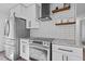 Modern kitchen with stainless steel appliances, white cabinets, granite countertops, and subway tile backsplash at 799 Kennesaw Dr, Forest Park, GA 30297
