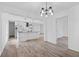 Open-concept living area with hardwood floors, neutral walls, modern lighting, and views into kitchen at 799 Kennesaw Dr, Forest Park, GA 30297