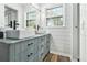 Bright bathroom featuring dual vessel sinks on a blue vanity with shiplap walls and wood-look flooring at 1757 Colonial South Sw Dr, Conyers, GA 30094
