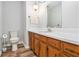 Well-lit bathroom featuring a modern toilet, sink, wood floors and ample cabinet space at 1757 Colonial South Sw Dr, Conyers, GA 30094