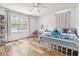 Bright bedroom with hardwood floors, a window, and a charming bed with a Stitch themed blanket and pillows at 1757 Colonial South Sw Dr, Conyers, GA 30094