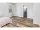 Bedroom showcasing a window and hardwood floors adjacent to a bathroom, offering comfort and convenience at 1757 Colonial South Sw Dr, Conyers, GA 30094