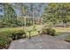 Concrete patio overlooking a landscaped backyard with mature trees, perfect for outdoor entertaining at 1757 Colonial South Sw Dr, Conyers, GA 30094