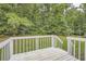Backyard view from wooden deck overlooking lush green trees, perfect for enjoying nature at 1945 Chateau Ln, Lithia Springs, GA 30122