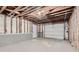 Unfinished basement area with exposed beams and a garage door, offering potential for customization at 1945 Chateau Ln, Lithia Springs, GA 30122