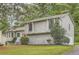 Charming home featuring stone accents, a red front door, a well-maintained lawn and mature trees at 1945 Chateau Ln, Lithia Springs, GA 30122