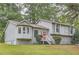 Charming home featuring stone accents, a red front door, a well-maintained lawn and mature trees at 1945 Chateau Ln, Lithia Springs, GA 30122